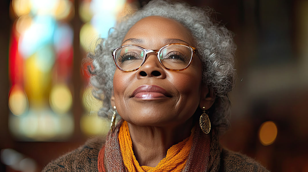Woman wearing glasses and an orange scarf with a blurred colorful background
